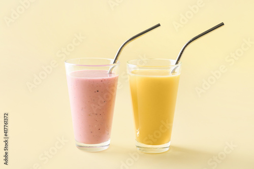 Glasses of tasty fruit and berry smoothie on color background