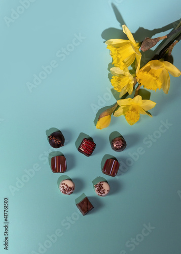 Yellow daffodils and chocolate candies. Flat lay,top view.