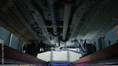 This video shows the underside of a car that is being repaired in a garage. photo