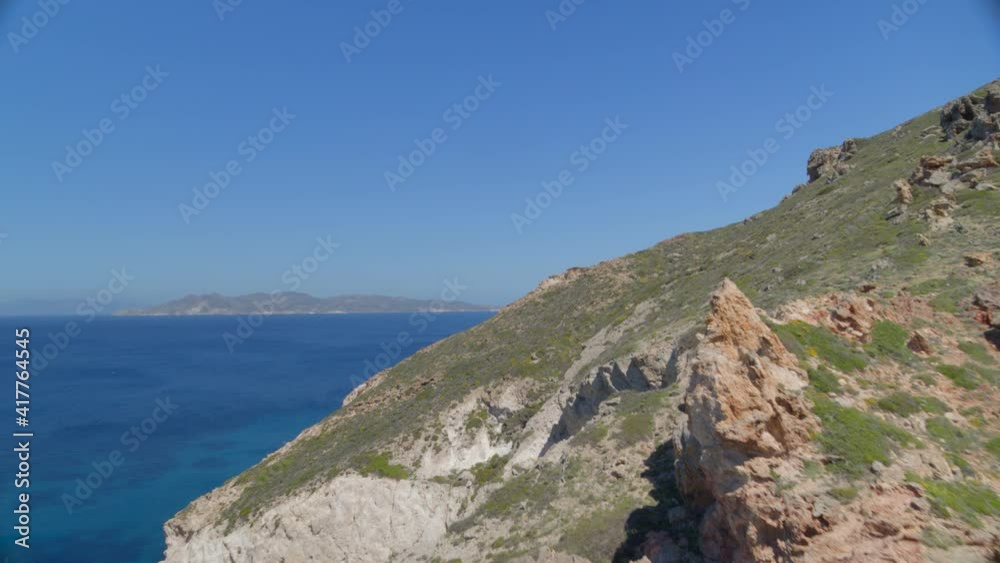 Flying Over Cliffs and Tilt Down Aerial View of the Blue Aegean Sea in Milos Flying Over Cliffs and Tilt Down Aerial View of the Blue Aegean Sea in Milos