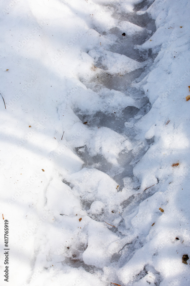 rozen tire track on a snowy road, road blocking vertical. rozen tire track on a snowy road, road blocking vertical.