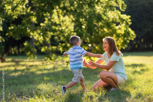 Little boy in park running towards his mother