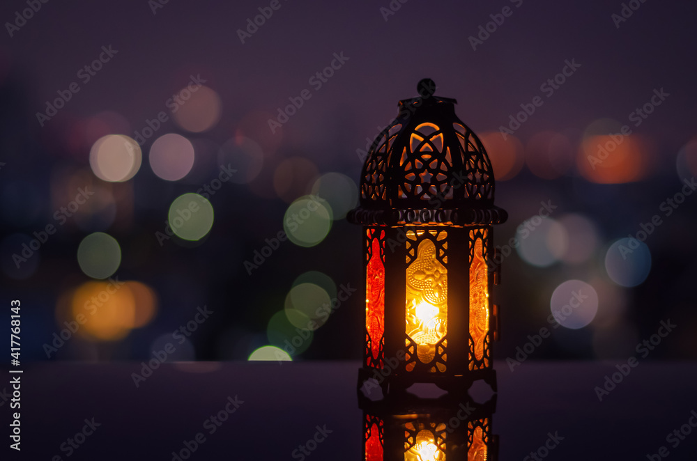 Lantern with night sky and city bokeh light background for the Muslim feast of the holy month of Ramadan Kareem.