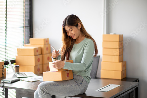 Small Business SME entrepreneur of Young Asian women working with laptop for Online shopping at home,Cheerful and Happy with box for packaging in home,Own Business Start up for Online shopping © David