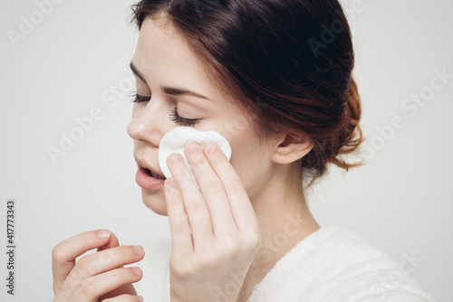 skin care woman wipes her face with white sponge
