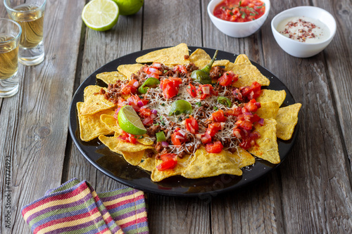 Corn chips nachos with meat, cheese, tomatoes and peppers. Mexican food. National cuisine.