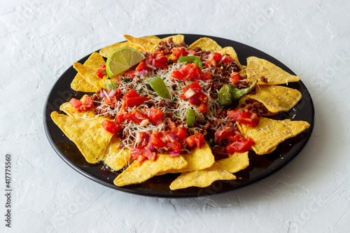 Corn chips nachos with meat, cheese, tomatoes and peppers. Mexican food. National cuisine.