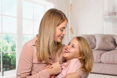 Shot of a happy cheerful mom hugging her little daughter with love