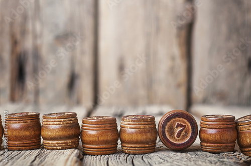 wooden barrels with numbers on a wooden background. the number seven is shown frontally photo