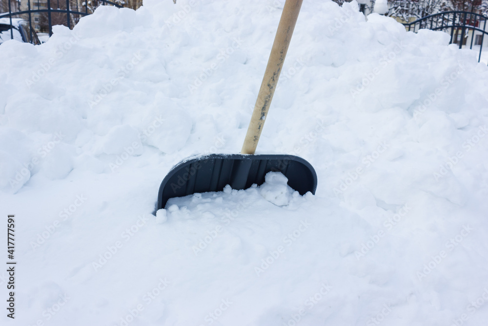 a large pile of snow with a shovel stuck in. snow removal. large amount of precipitation in winter a large pile of snow with a shovel stuck in. snow removal. large amount of precipitation in winter