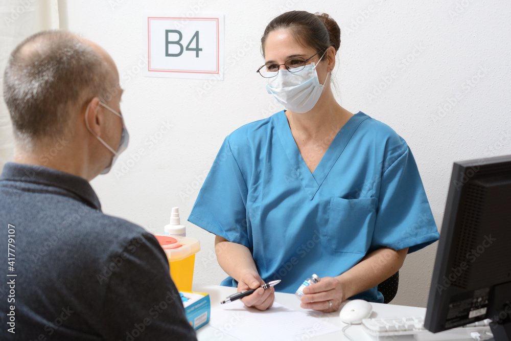 Doctor as vaccinologist in vaccination center advises patient before vaccination against corona virus Doctor as vaccinologist in vaccination center advises patient before vaccination against corona virus