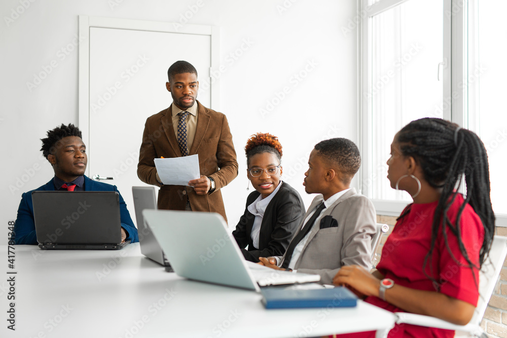 team of young african people in the office at the table with laptops 