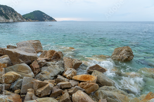 Closeup shot of waves washing the rocky coast of Sansone beach, Island of Elba photo