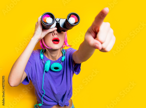 Young style girl in purple clothes with binoculars