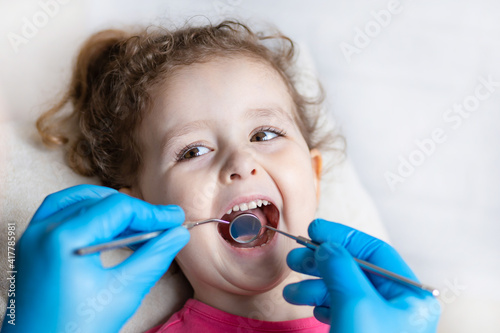 examination, treatment teeth children. medical checkup oral cavity with instruments. dental hands, child in clinic. Cute girl smiling stomatology. Happy kid in dentist chair. concept health, medicine