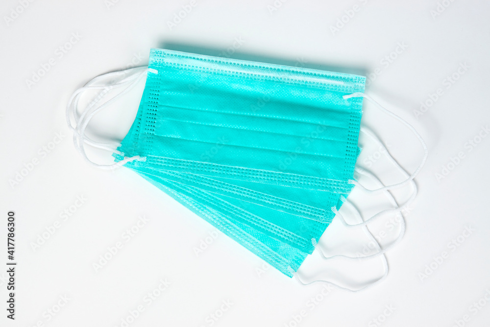Green medical mask on white background, close-up Green medical mask on white background, close-up