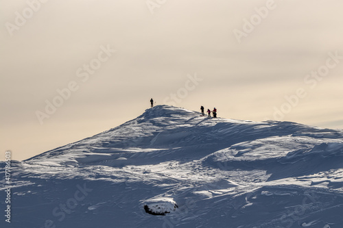 Skiers on top of a mountain peak