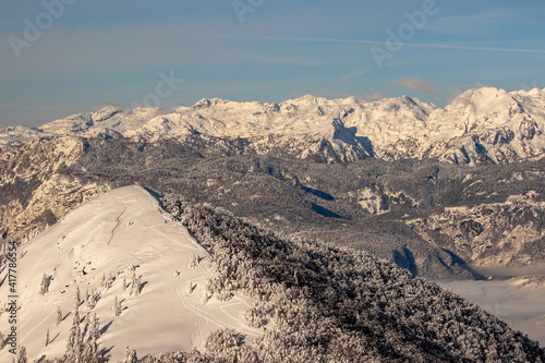 Skiers on small peak with Bohinj valley in the background