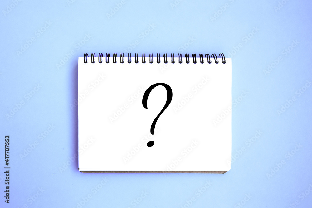 Open notebook with white blank pages on blue background. Notepad with a drawn question mark. Stationery on a blue background with space for text. Minimalism. Flat lay Open notebook with white blank pages on blue background. Notepad with a drawn question mark. Stationery on a blue background with space for text. Minimalism. Flat lay