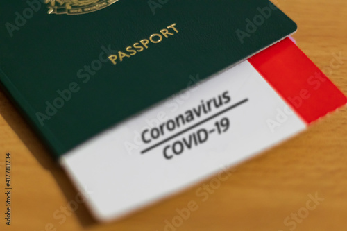 Vaccine Passport Concept. COVID-19 vaccination proof on a card tucked inside the passport.