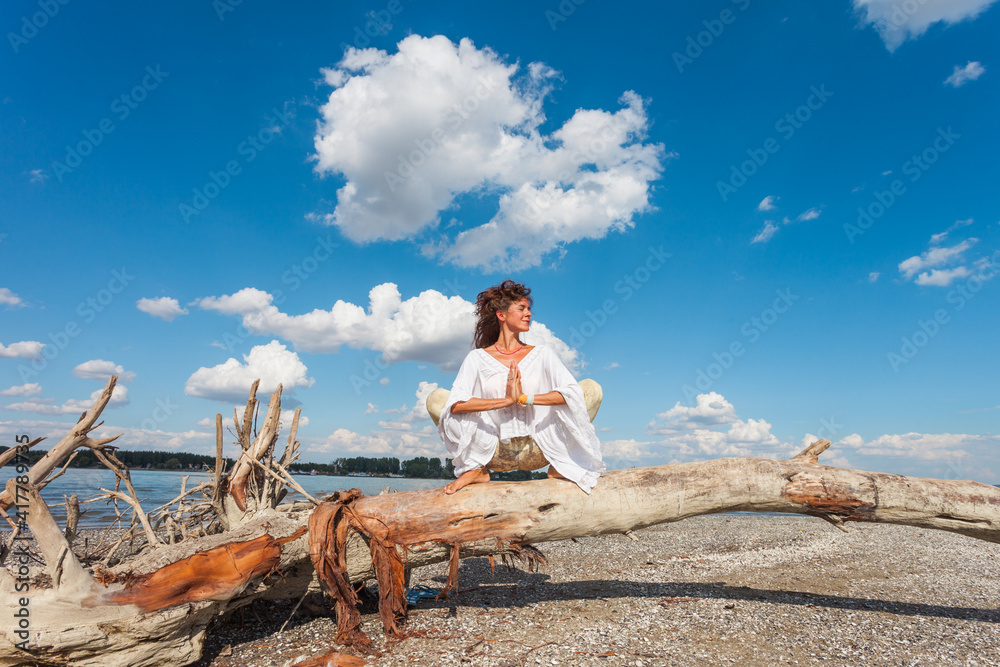 healthy lifestyle young woman practice yoga on  dried trunk on the river beach fresh air sunny summer day