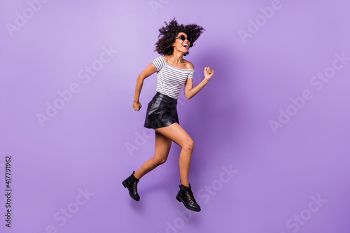 Full size profile photo of crazy pretty dark skin lady have fun hurry fast toothy smile isolated on violet color background