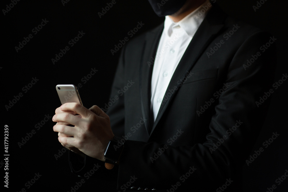 Cropped image of businessman in classical suit is using smart phone. Close up. Cropped image of businessman in classical suit is using smart phone. Close up.