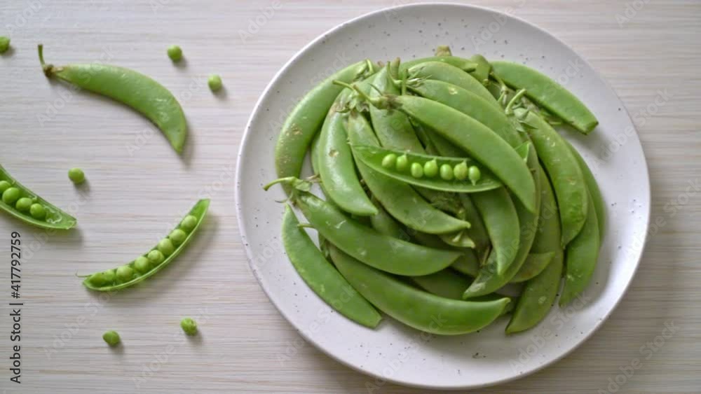 fresh sweet green peas on white plate fresh sweet green peas on white plate