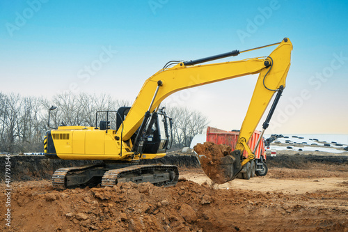 A large construction excavator of yellow color on the construction site in a quarry for quarrying. Industrial image