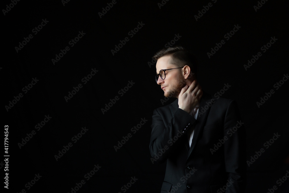 Man with in suit and eyeglasses with closed eyes on a black background with copy space. Man with in suit and eyeglasses with closed eyes on a black background with copy space.