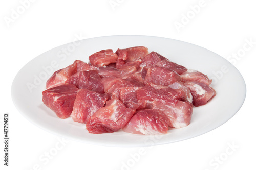 Pieces of raw meat on a white plate
