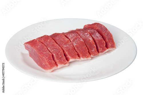 Pieces of raw meat on a white plate