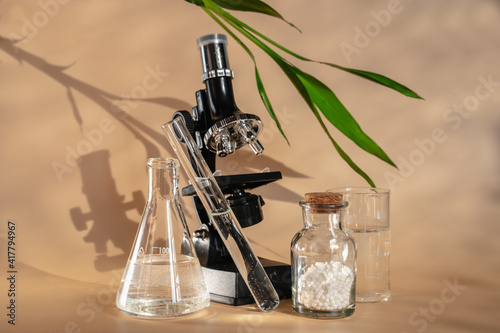 Homeopathy is an alternative medicine. Microscope and flasks for studying homeopathy. Green bamboo leaf. Laboratory for creating homeo balls. photo