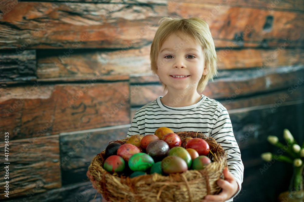 Fototapeta premium Sweet toddler child, cute boy playing with colorful easter eggs
