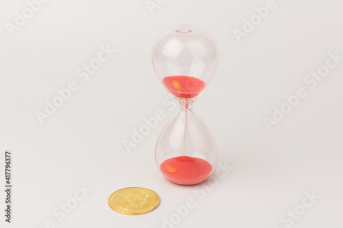 Hourglass and golden bitcoin. Currency time concept