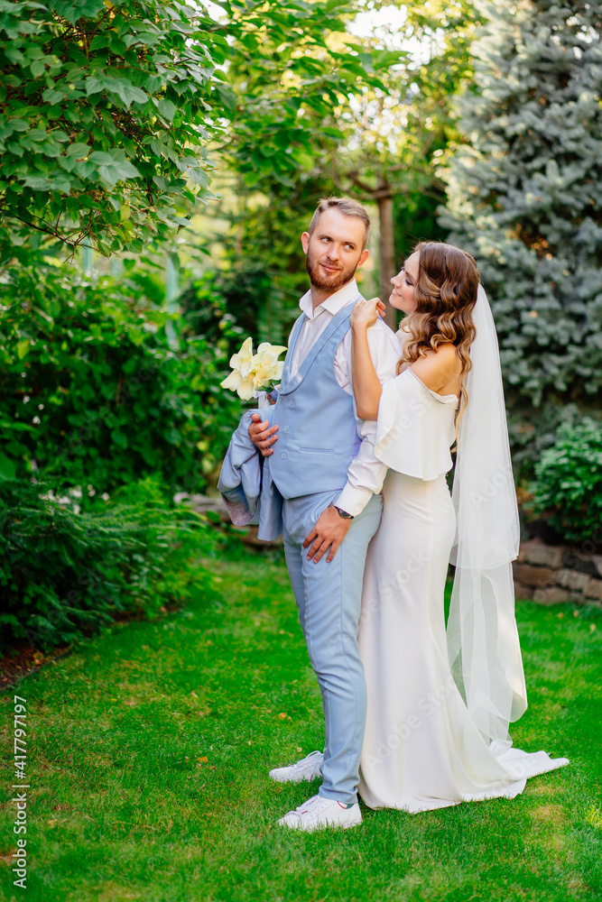 Walking newlyweds in the summer garden. wedding photo shoot in the park. Walking newlyweds in the summer garden. wedding photo shoot in the park.