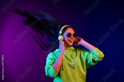 Photo of nice pretty happy lady look empty space fly hair wear headphones sunglass isolated on neon background
