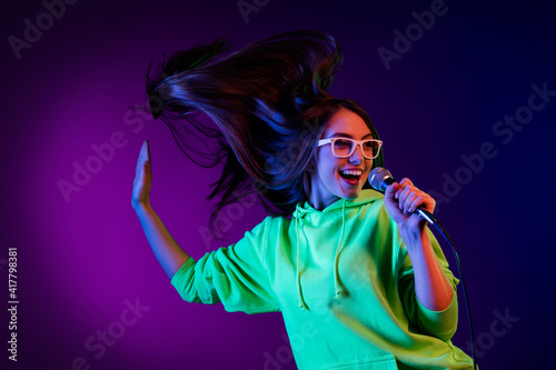 Photo of attractive positive young woman sign hold microphone isolated on gradient violet color background