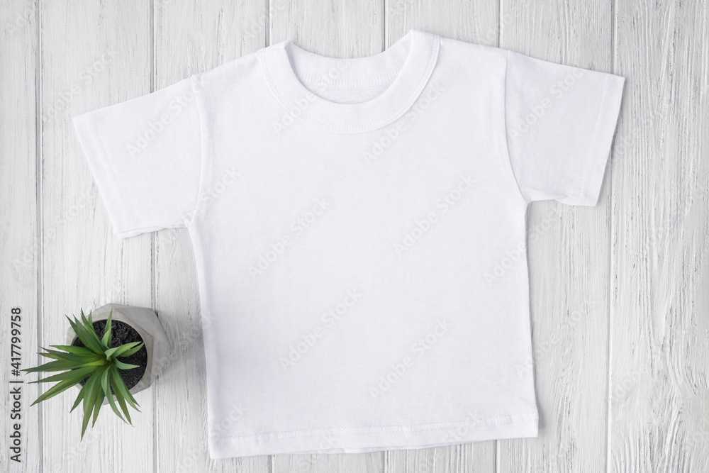 White tshirt mockup with succulents on wooden table background. Template, flat lay