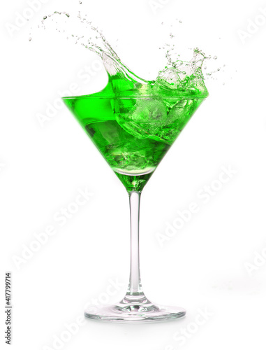 green cocktail splashing into a martini glass isolated on white background