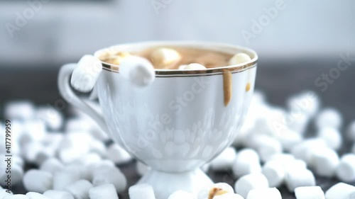 a cup of coffee on a dark table with marshmallows, scattered marshmallows, sweet coffee, cappuccino, latte