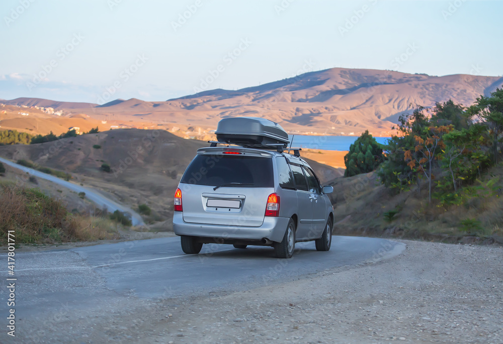 Travelers by car move along winding road to the sea