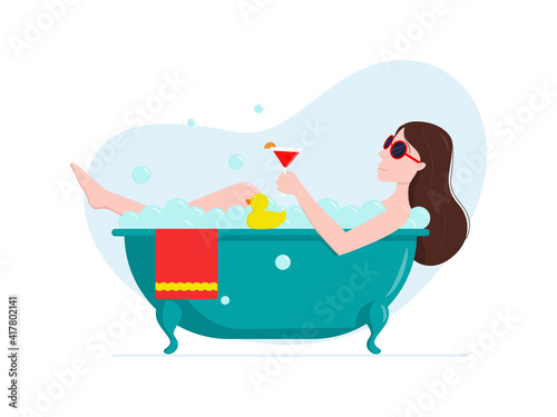The woman is taking a bath with a glass of drink. Holiday home concept.