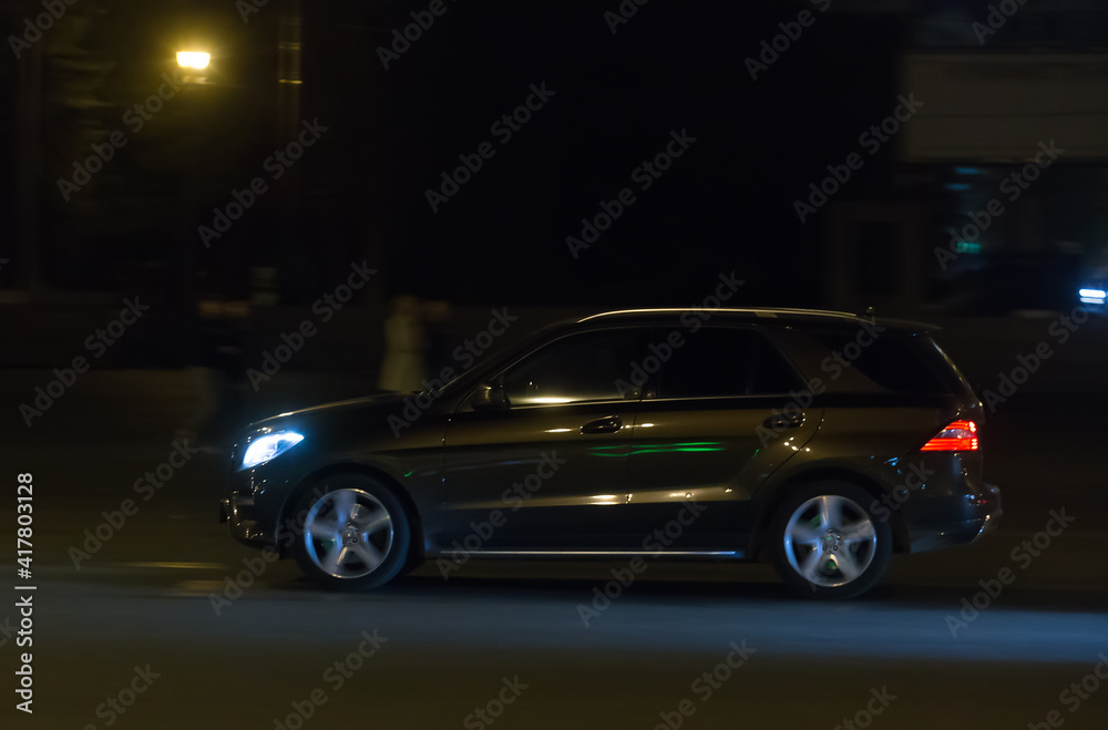 SUV moves at night on city street