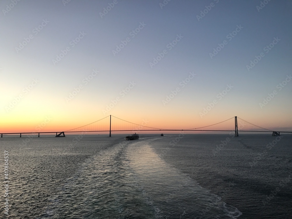 Brücke Hängebrücke Spannbeton Hohlkastenbrücke  Storebæltsbroen Brückenzug  in Dänemark in der Meerenge Großer Belt zwischen den Inseln Fünen und Seeland von einem Kreuzfahrtschiff bei Sonnenuntergang