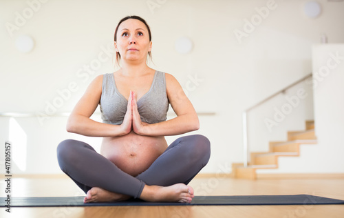 pregnant woman is engaged in yoga. Easy pose or Sukhasana.