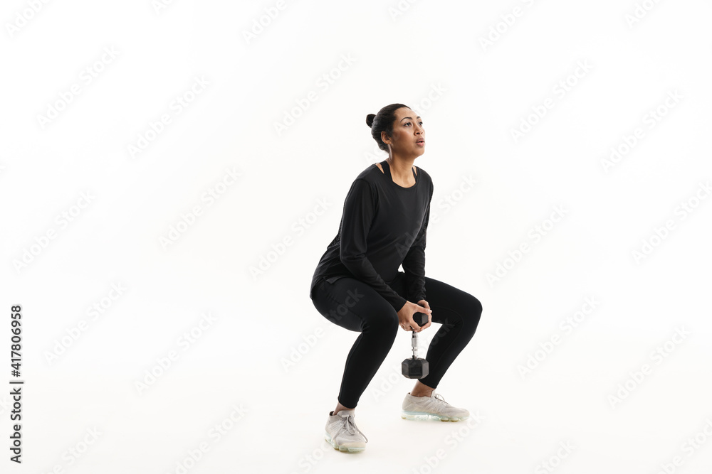 Focused african american woman working out with dumbbell Focused african american woman working out with dumbbell