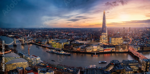 Panoramic view to the illuminated skyline of London, United Kingdom, during sunset time with sun and rain