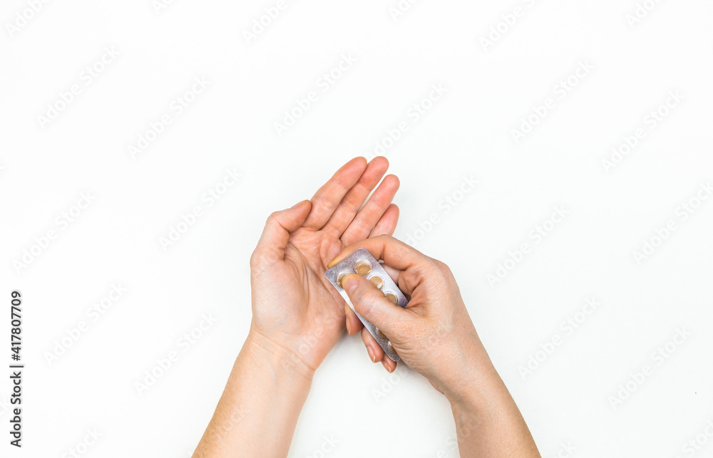 medicines in the hand of a woman on a white background medicines in the hand of a woman on a white background