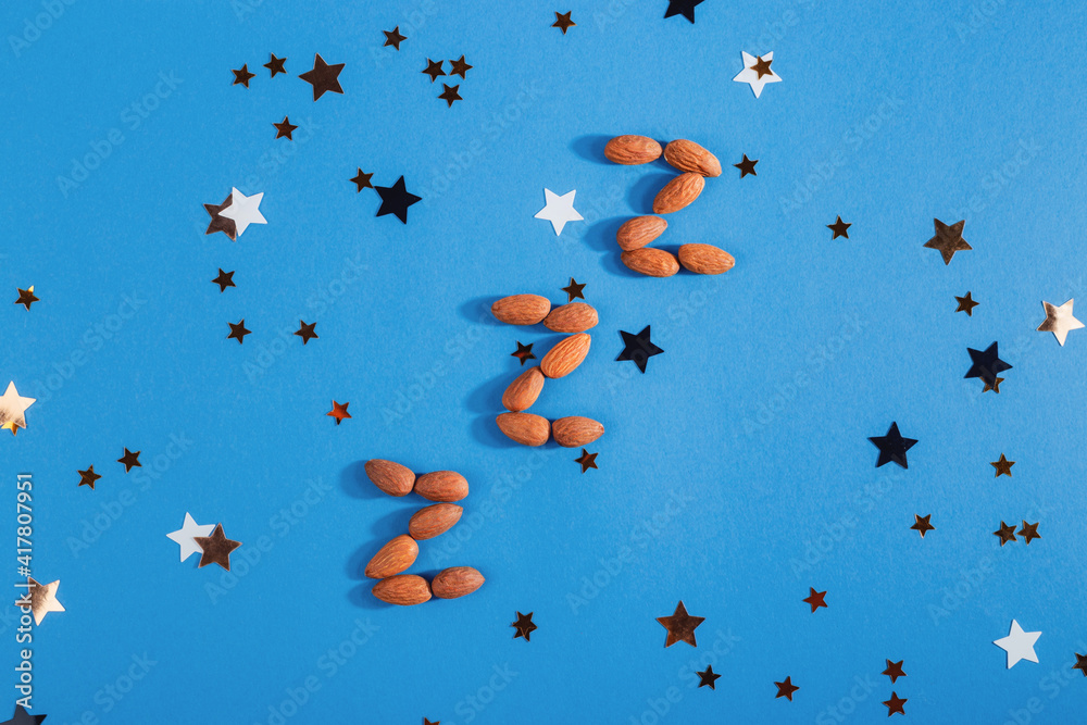 Z-shaped almonds as a product to restore healthy sleep and treat insomnia. Top view, flat lay Z-shaped almonds as a product to restore healthy sleep and treat insomnia. Top view, flat lay